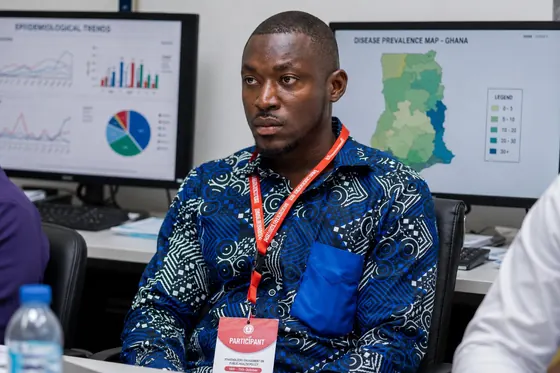 Valentine Golden Ghanem - As a conference participant, reviewing epidemiological data on screen.