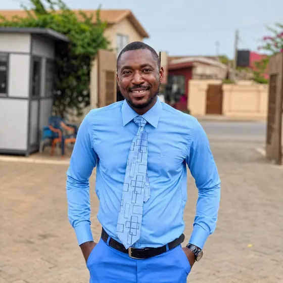Valentine Golden Ghanem - Portrait on a residential street, light blue shirt.