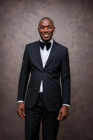 Valentine Golden Ghanem - Studio portrait in a black tuxedo and bow tie.